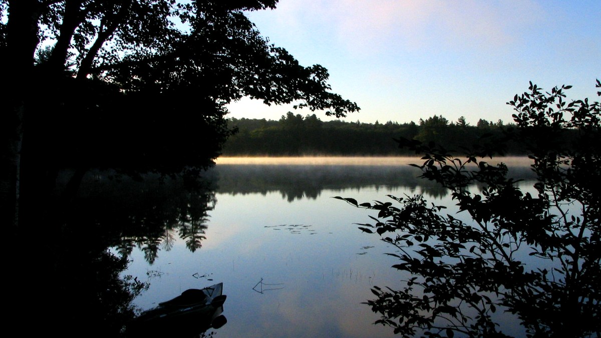 Canoë au bord de l’eau dans une ambiance de bivouac matinal