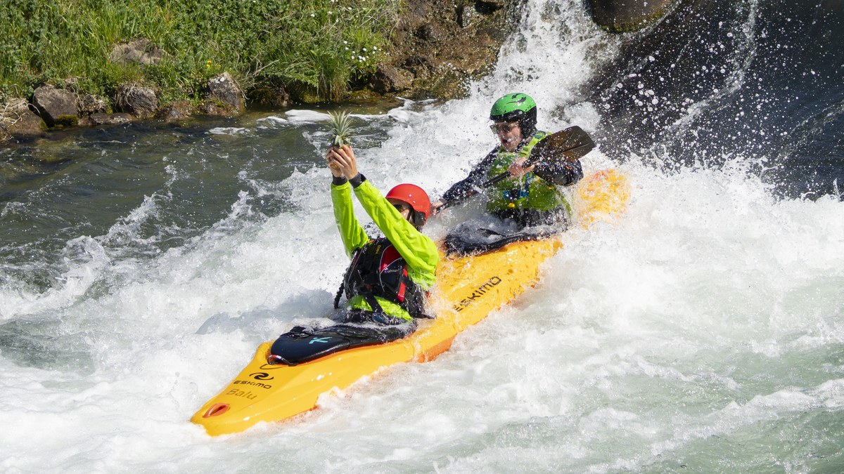 Deux kayaks colorés franchissent un rapide sur une rivière d’eau vive