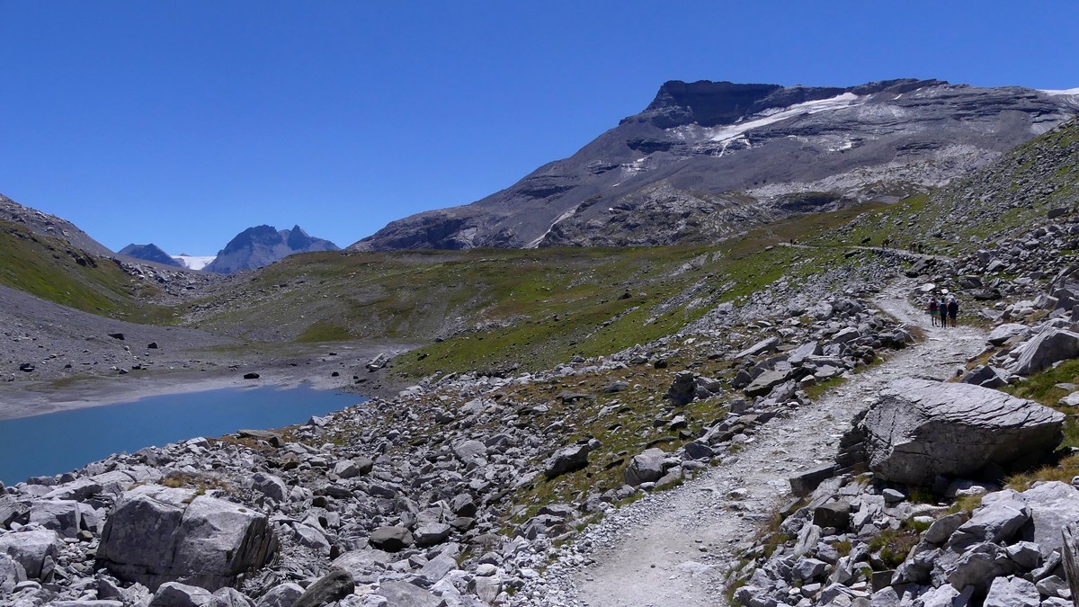 Sentier de randonnée près d’un lac avec relief de montagne