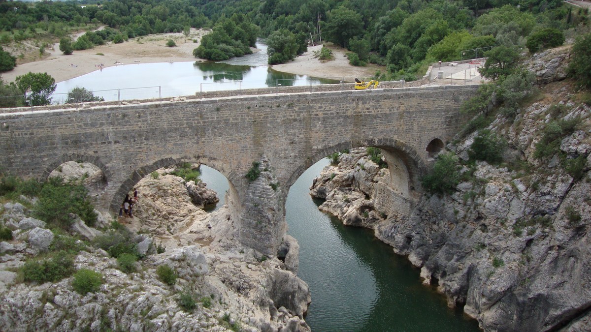 Canoë sur une rivière claire entre falaises calcaires dans les gorges de l’Hérault