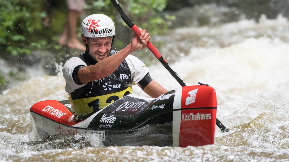 Canoë sur une rivière calme entre falaises et berges boisées en Dordogne