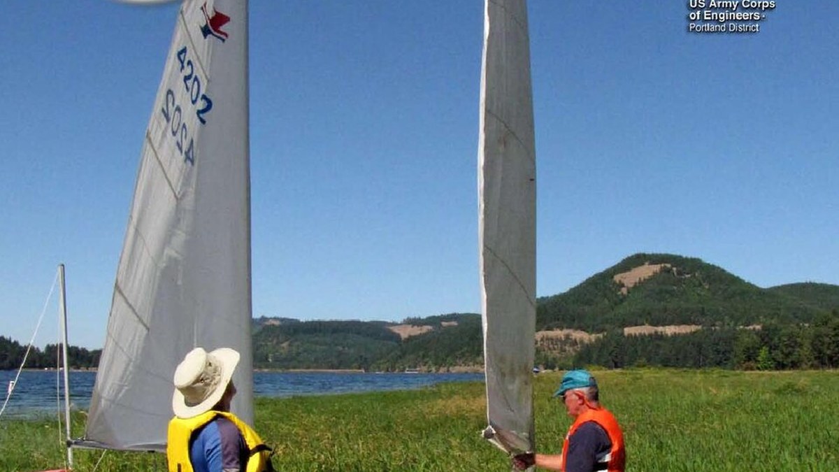 Randonneur sortant une doudoune de son sac à dos sur un sentier de montagne froid