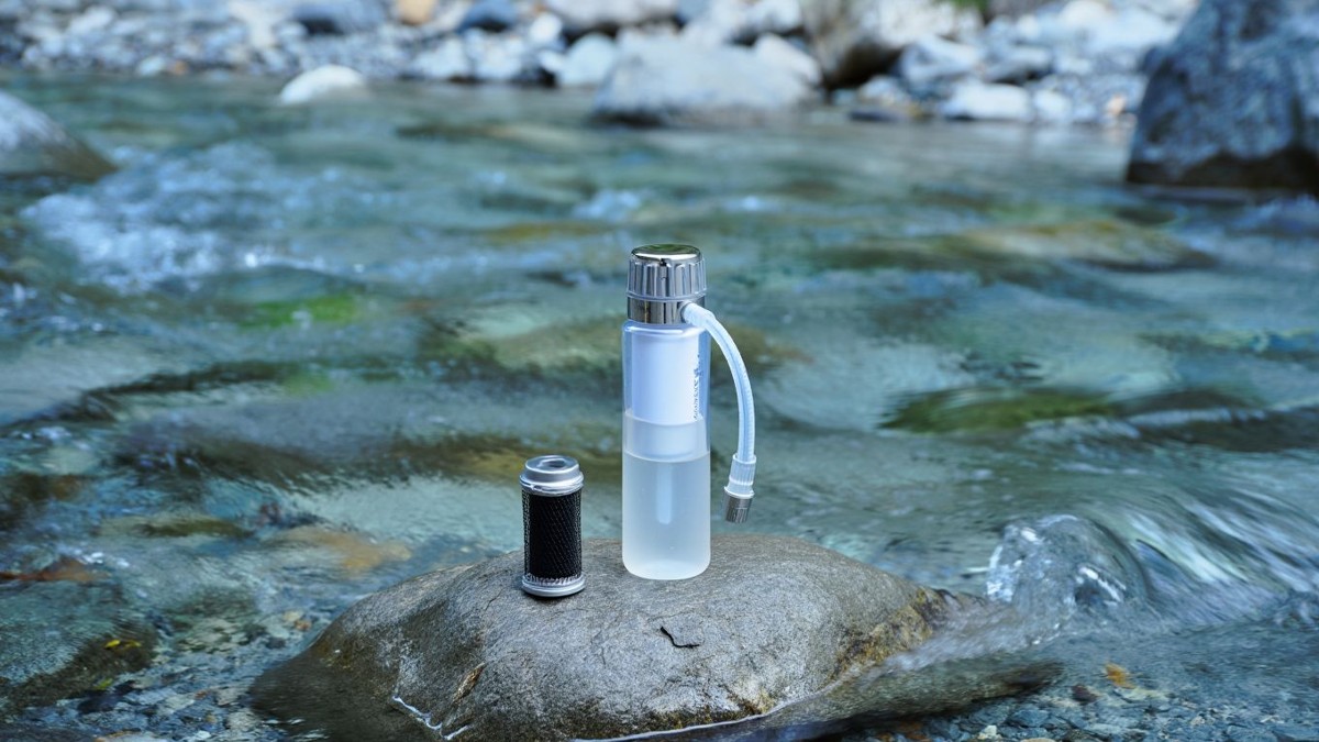 Gourde filtrante et cartouche au bord d’une rivière de montagne
