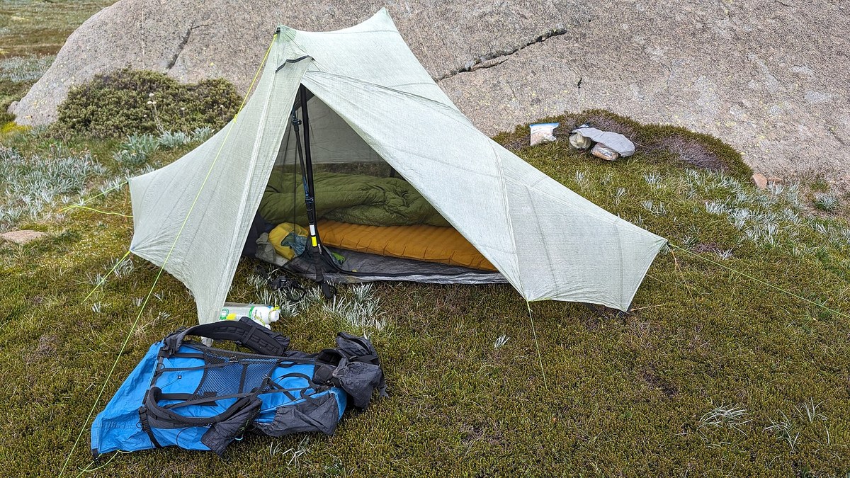 Matelas et couchage de bivouac installés près d une tente sur un emplacement de camping
