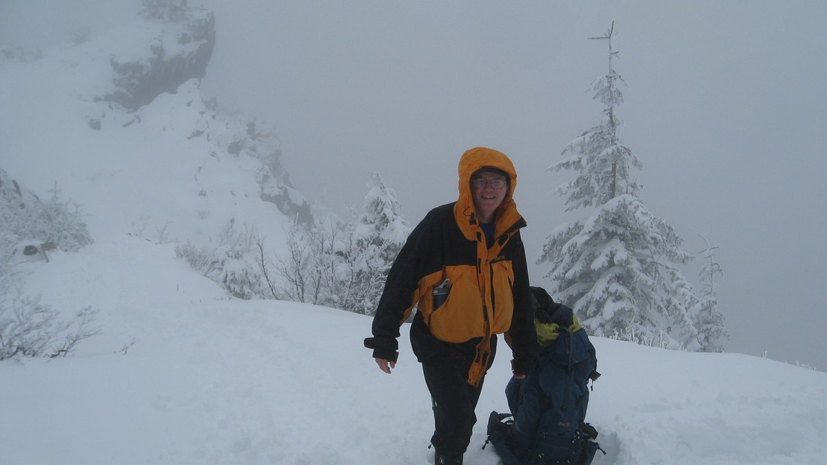 Randonneur ajustant des micro-crampons sur ses chaussures dans la neige